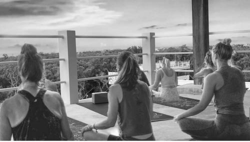 a group of women sitting on a balcony looking at the view at Costa Nube in Caye Caulker