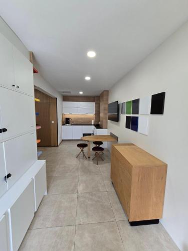 a living room with a table and a kitchen at Apartment ARSO in Velenje