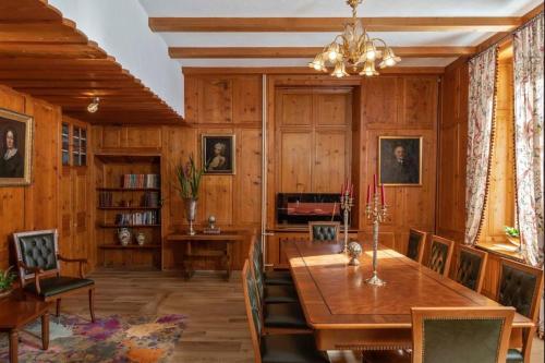 a dining room with wooden walls and a table and chairs at Mineral Water Resort Hotel Bad Serneus in Klosters