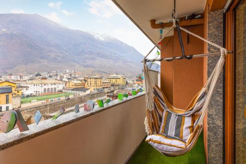 a hammock on a balcony overlooking a city at 1min from Bernina Express - Mountain View - AC - WiFi in Tirano