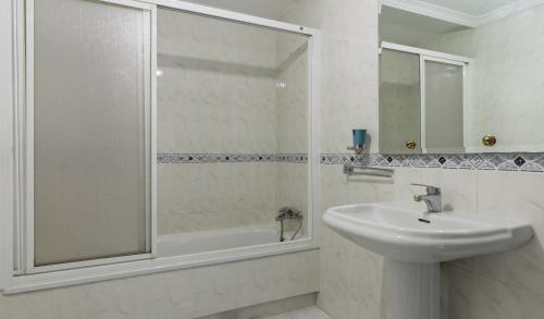 a white bathroom with a sink and a shower at Vivienda Alló in Rois