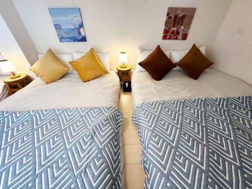two beds sitting next to each other in a room at Easy go to Hakata and Tenjin, Close to FKK Airport in Itazuke