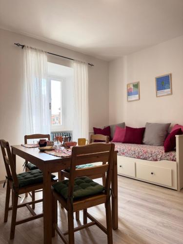 a living room with a table and a couch at Appartamento in pieno centro - La Piazzetta in Passignano sul Trasimeno