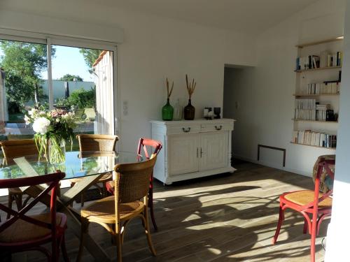 une salle à manger avec une table et des chaises en verre dans l'établissement Château d'Oléron La Maison Bleue, au Château-dʼOléron