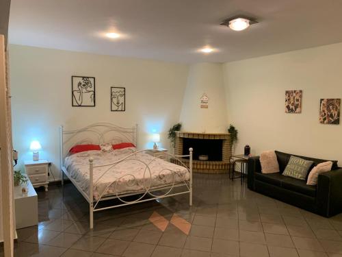 a bedroom with a bed and a couch and a fireplace at Eden Garden near Knossos in Skalánion
