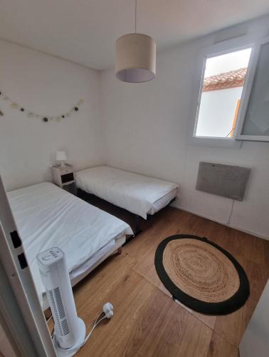 une petite chambre avec deux lits et une fenêtre dans l'établissement Duplex 2 chambres vue panoramique Mer, au Barcarès