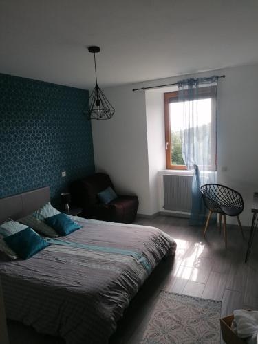 une chambre avec un lit, un canapé et une fenêtre dans l'établissement La Maison de Valie, à Mercoeur