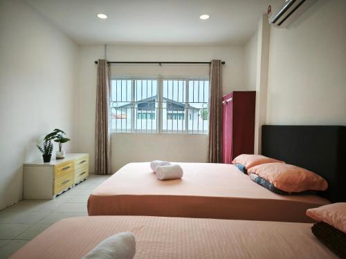 a bedroom with two beds and a window at Miri Homie Homestay 2 in Miri
