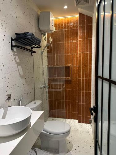 a bathroom with a white toilet and a sink at Cana House Coffee & Stay in Sentool