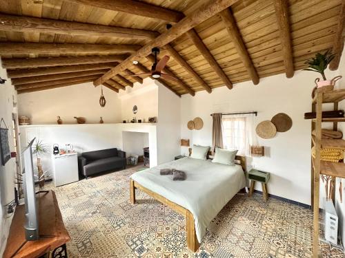 a bedroom with a large bed and a couch at Alpaca Farm And B&B - Mama Adama in Grândola