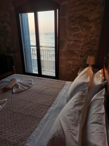 a bedroom with a bed with a view of the ocean at Volakas Beachfront Suites in Rethymno Town