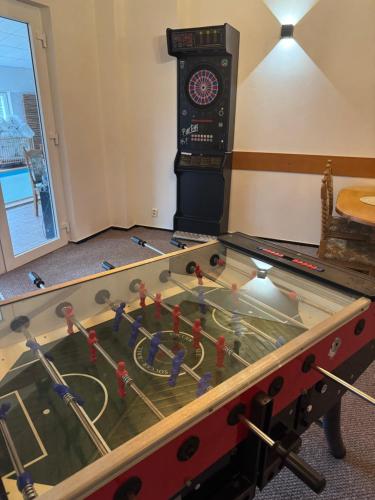 a ping pong table in a room with a clock at Penzion Berany in Jablonec nad Nisou