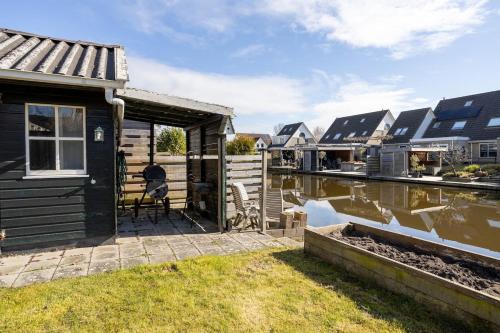 a house with a deck next to a body of water at Large waterfront family home! in Workum