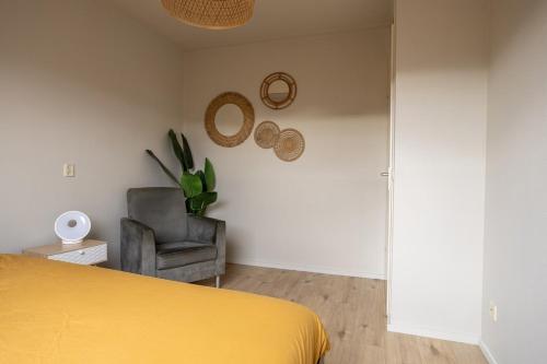 a bedroom with a yellow bed and a chair at Large waterfront family home! in Workum