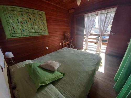 a bedroom with a large bed with a window at La Tatuira, Cabana Amarela in Pinheira