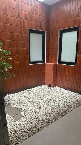 two windows in a brick wall with a bird sitting in it at Cana House Coffee & Stay in Sentool