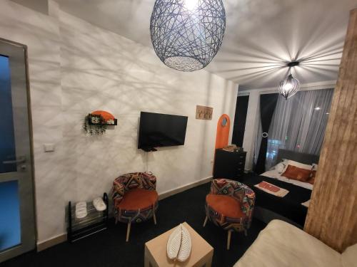 a living room with two chairs and a television at Studio lux Strpce in Brezovicë