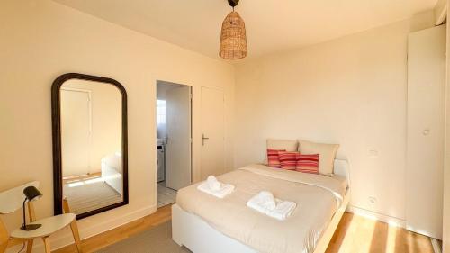 une chambre avec un lit et un grand miroir dans l'établissement Villejuif aux portes de Paris, à Villejuif