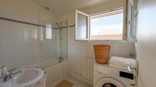 une salle de bain avec une machine à laver et un lavabo dans l'établissement Villejuif aux portes de Paris, à Villejuif