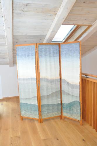 two windows in a room with wooden floors at Hiša Manira in Ajdovščina
