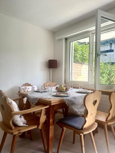 a dining room with a table and chairs and a window at Apartment Blick Lischana- ein Traum mit Bergpanorama, Sauna, Hottub in Scuol
