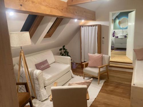 a living room with a white couch and chairs at Biohof zum Grünen Baum in Porrau