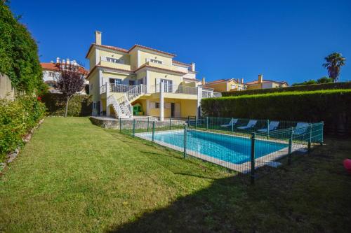 a house with a swimming pool in front of a house at Spacious 4-Bedroom Villa with Private Heated Pool in Quinta da Beloura Sintra Ideal for Families & Long Stays in Sintra