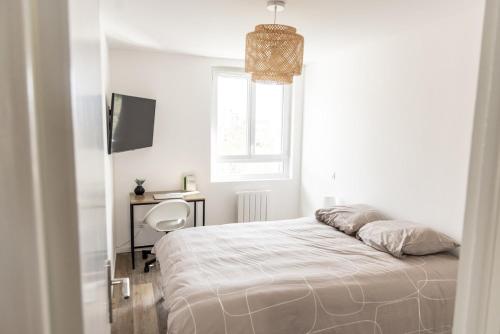 une chambre blanche avec un lit et un bureau dans l'établissement Les chambres d'Arnaud - appartement partagé de 3 chambres, à Toulouse