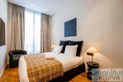 une chambre avec un lit avec une chaise et une fenêtre dans l'établissement Urban Flat 197 - Appartement Saint Honore Champs Elysees, à Paris