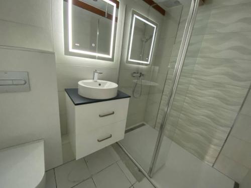 une salle de bain blanche avec un lavabo et une douche dans l'établissement Villa T3 Mezzanine 6 pers. avec piscine, parking privé, proche plage et commerces - FR-1-81-270, au Barcarès