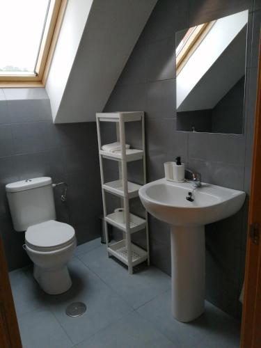 a bathroom with a sink and a toilet and a mirror at Ático en Ribeira Ría de Arousa in Ribeira