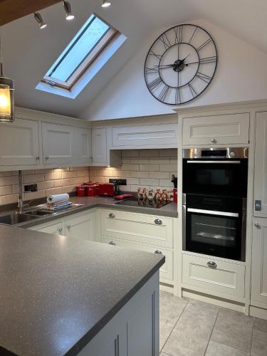 a kitchen with a clock on the wall and a counter at Modern 1-Bedroom Apartment in Holt in Holt