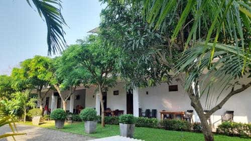 a building with trees in front of it at Hotel Sanhida Polonnaruwa in Polonnaruwa