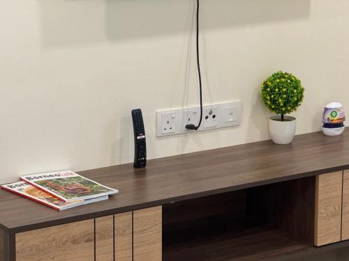 a desk with a remote control and a plant on it at 4 Pax - Scenic Riverfront Studio B, Kuching City in Kuching
