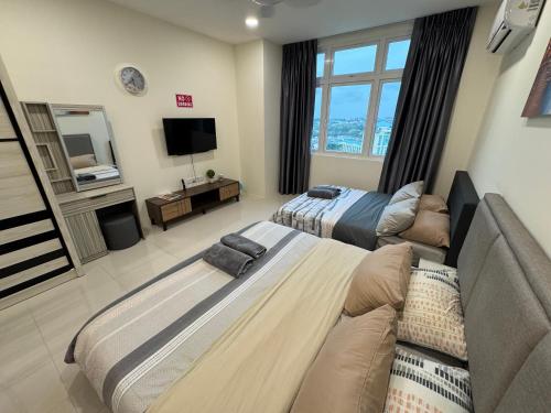 a living room with two beds and a television at 4 Pax - Scenic Riverfront Studio B, Kuching City in Kuching