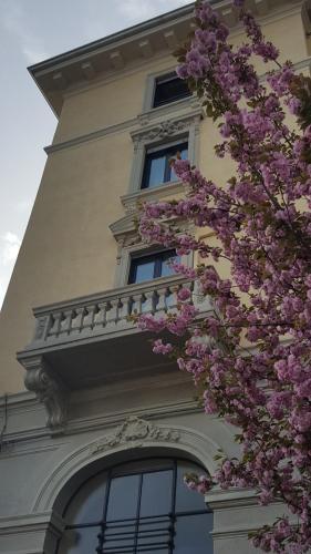 a building with a balcony and purple flowers at Hotel La Nuova Rotaia in Gallarate