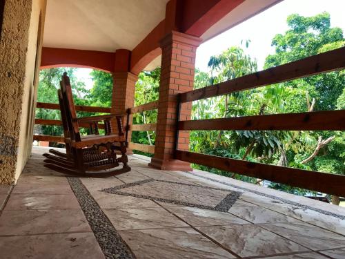 eine Veranda mit einer Bank und einem Zaun in der Unterkunft Departamento de descanso en rancho. in Guasave