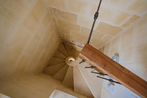 an attic room with a staircase and a ceiling at Virginia Farmhouse in Kerċem