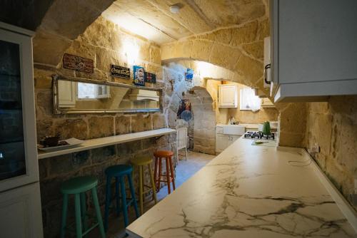 a kitchen with a counter and stools in a room at Virginia Farmhouse in Kerċem