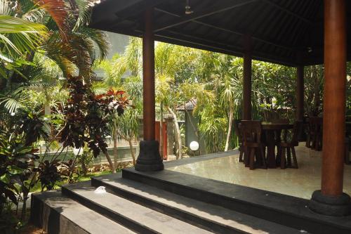a porch of a house with a table and chairs at The Gecho Inn Country in Jepara