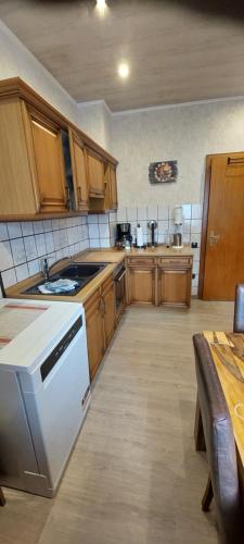 a kitchen with wooden cabinets and a white stove top oven at Ramiwi am Teutoburger Wald in Oerlinghausen