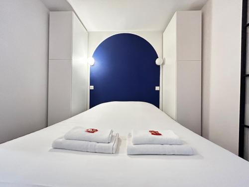 a bedroom with a white bed with two towels at E5 Reton T2 chic et confortable au coeur d Epernay in Épernay