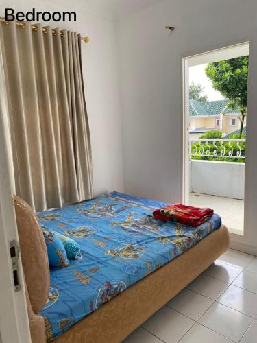 a bed sitting in a room with a window at Villa Puncak Resort Cipanas in Cikundul