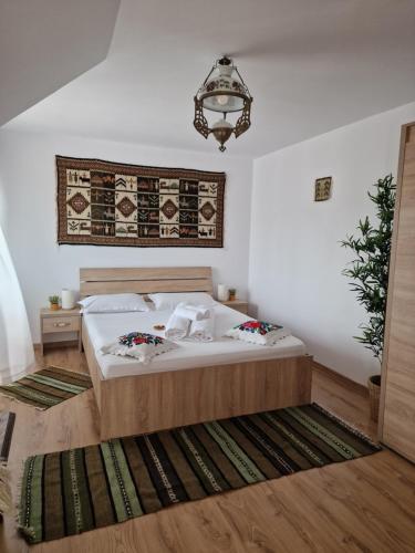 a bedroom with a bed and a chandelier at Casa Tomșa in Rozavlea