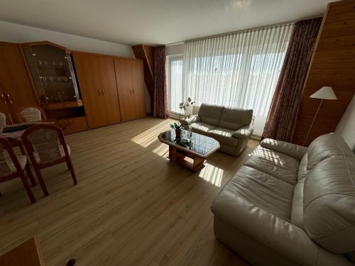 una sala de estar con un sofá y una mesa en Aparthotel HAUS USEDOM, en Kolpinsee