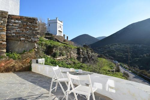 a table and chairs on a balcony with a view of a mountain at Arch House Sifnos in Apollonia
