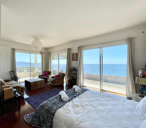 a bedroom with a large bed with a view of the ocean at Casamea - Sagone, Villa Vue Mer, Clim, Piscine in Coggia