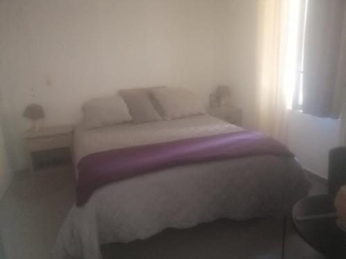 - une chambre avec un lit doté de draps et d'oreillers violets dans l'établissement Hébergement de vacances à riez à 10 minutes environ du lac de sainte Croix du Verdon, à Riez