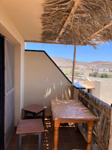 a table and two benches on a balcony with a view at Playa de la Fuente in Lajita