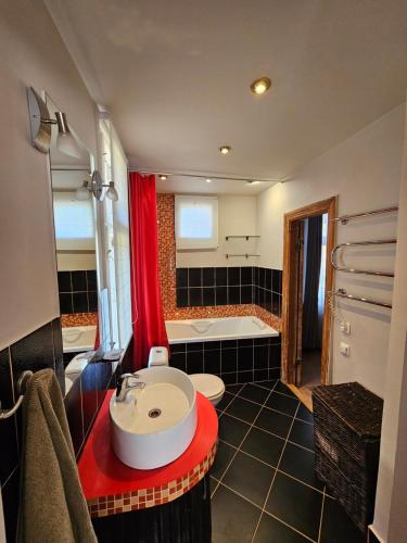 un baño con lavabo y bañera en White House Apartment, en Jūrmala